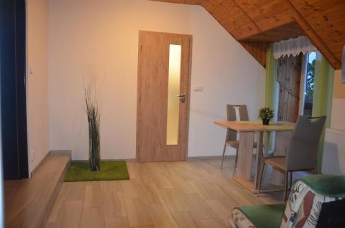 a living room with a table and a door at penzion U Koníčka in Strážiště