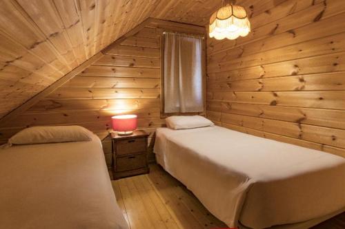 a bedroom with two beds and a lamp and a window at Luna Chalets da Montanha - Serra da Estrela in Covilhã