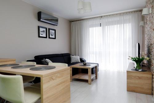 uma sala de estar com uma mesa e um sofá em Apartament Teresa w Uniejowie em Uniejow