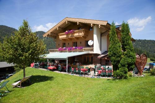 a building with tables and chairs in front of it at Alpengasthof Oberweissbach in Waidring
