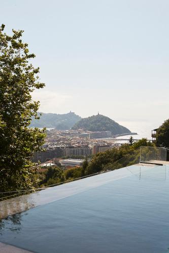 a large swimming pool with a view of the ocean at Boutique Hotel Mendi Argia in Donostia-San Sebastián
