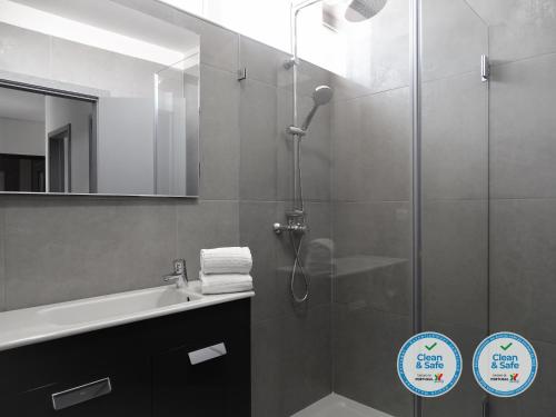 a bathroom with a shower and a sink and a mirror at RS Porto Apartments in Porto