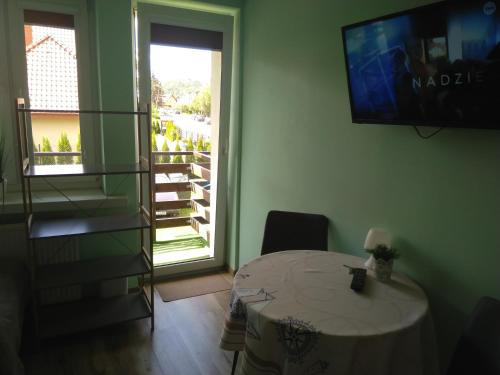a room with a table and a sliding glass door at Pokoje Gościnne Bajka in Rumia