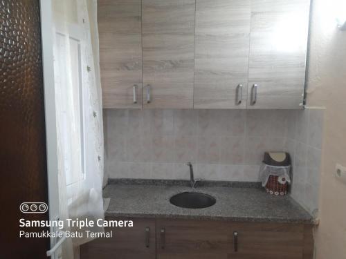 a kitchen counter with wooden cabinets and a sink at Pamukkale Batu Termal in Pamukkale