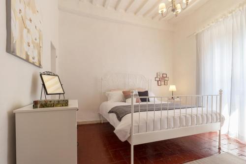 biała sypialnia z łóżkiem i oknem w obiekcie Il Cuore di Chiusi - Autentica Casa in Toscana w mieście Chiusi