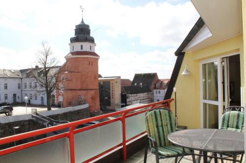 uma varanda com uma mesa e cadeiras e um farol em Ferienwohnung am Schloss em Ueckermünde