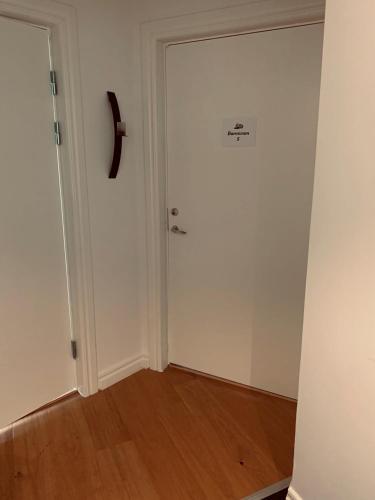 a room with a white door and a wooden floor at Stekhuset B&B in Kalmar
