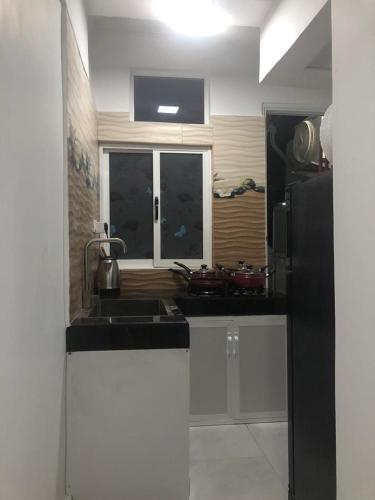 a kitchen with a sink and a black refrigerator at WISH RESIDENCE SeaSide, Near Durdans & Vasan eye care Hospital, Colombo 3 in Colombo