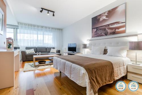 a bedroom with a bed and a living room at RS Porto Boavista Studios in Porto