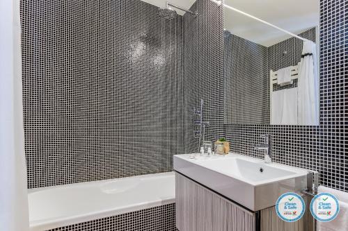 een badkamer met een wastafel, een bad en een wastafel bij RS Porto Boavista Studios in Porto