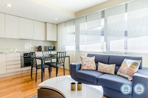 a living room with a blue couch and a table at RS Porto Boavista Studios in Porto