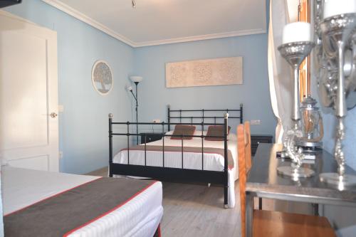 a bedroom with two beds and a table at Hostería El Bodegón De Gredos in Arenas de San Pedro