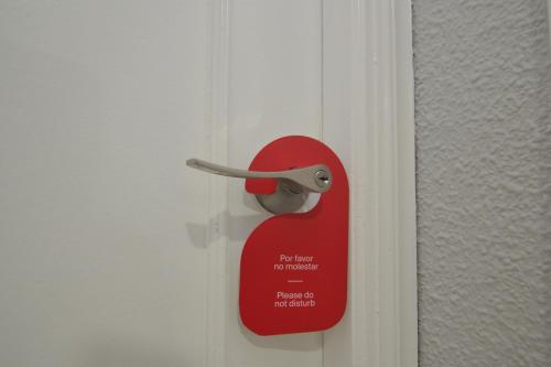 a red door lock on a white door at Hostería El Bodegón De Gredos in Arenas de San Pedro