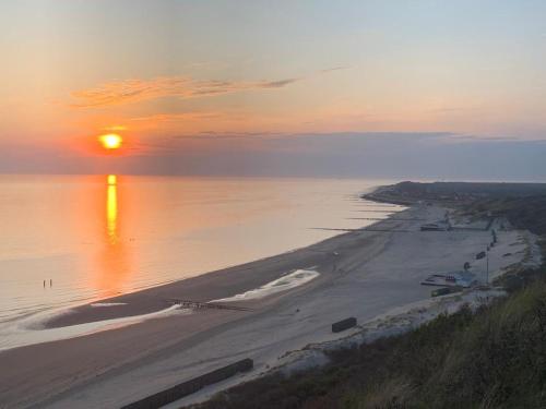 an aerial view of a beach at sunset at Studio Zwin 9 in Zoutelande