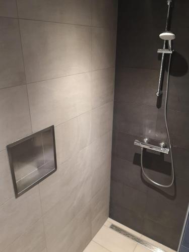 a bathroom with a shower with a glass door at Studio Zwin 9 in Zoutelande
