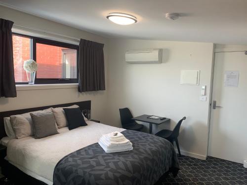 a bedroom with a bed and a table and a window at Queens Arms Hotel in Longford