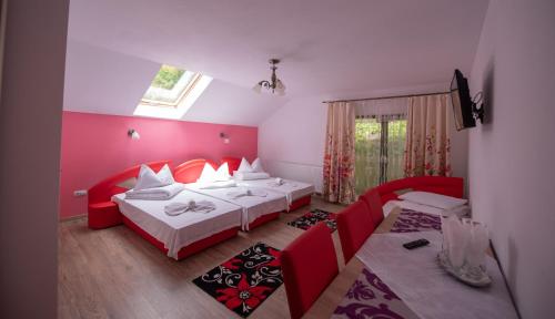 シゲトゥ・マルマツィエイにあるDupa apa la Razvanのベッドルーム1室(ベッド2台、ソファ、窓付)