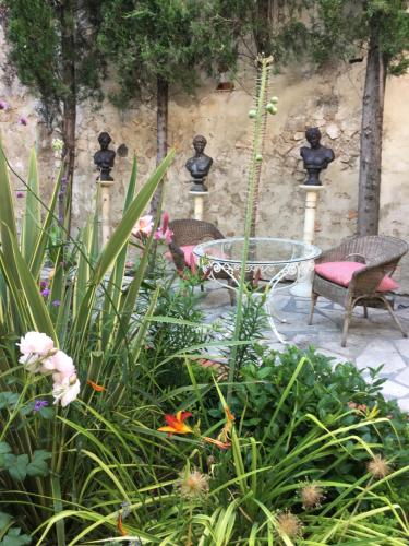a garden with two chairs and a table and flowers at Casa San Roque in Chinchón