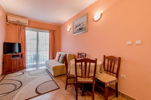 sala de estar con sofá, mesa y sillas en Apartments Gudelj en Kamenari