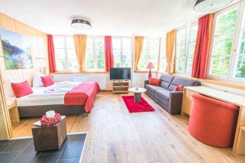 a living room with a bed and a couch at Boutiquehotel Hubertushof in Bad Ischl