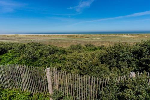a fence with trees and the ocean in the background at Evancy Platier d'Oye - Oye-Plage in Oye-Plage