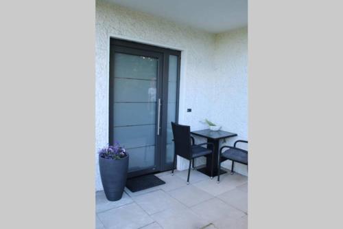 a patio with a table and chairs and a door at Moderne Ferienwohnung mit privatem Eingang - ROSA in Kalletal