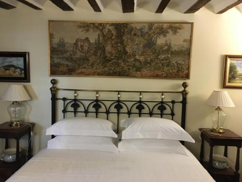 1 dormitorio con 1 cama con una pintura en la pared en Casa San Roque, en Chinchón