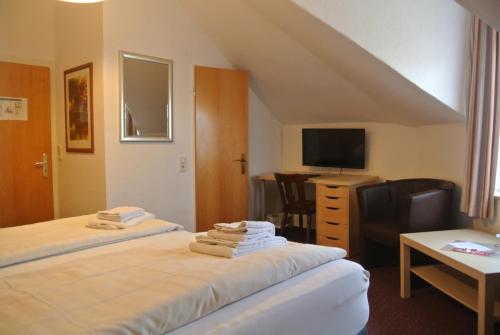 a hotel room with two beds and a television at Hotel Am Kamin in Duisburg