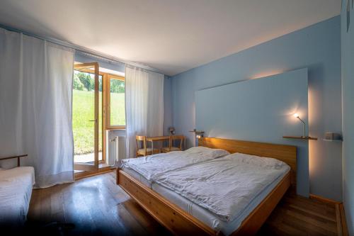 a bedroom with a large bed and a window at Bühnenwirtshaus Juster in Gutenbrunn