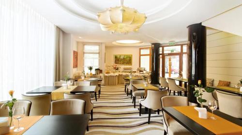 restauracja ze stołami i krzesłami oraz żyrandolem w obiekcie Komturia Old Town by Fahrenheit w Gdańsku