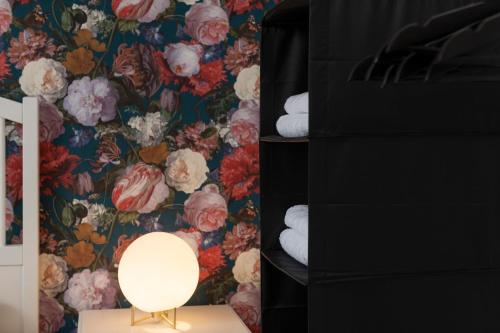 a bedroom with a floral wallpaper with a lamp and towels at Zu Hause im schönen Tirol in Kirchbichl