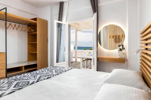 a bedroom with a bed and a view of the ocean at Golden Beach Hotel in Chrissi Akti