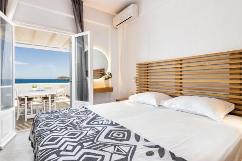 a bedroom with a bed and a view of the ocean at Golden Beach Hotel in Chrissi Akti