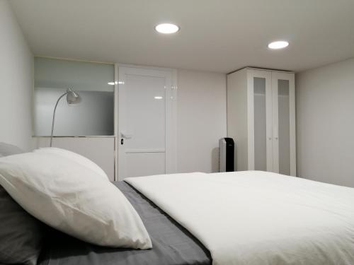 sypialnia z białym łóżkiem i lampką w obiekcie HomeForGuest BIOMA Modern & Minimalist Apartment w mieście Santa Cruz de Tenerife