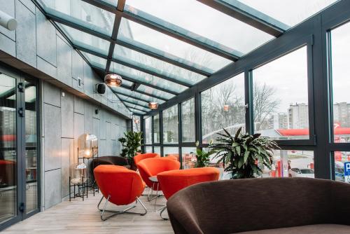 a lobby with orange chairs and windows at Krowodrza Centrum Konferencyjno - Hotelowe in Kraków