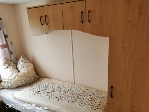 1 dormitorio con 1 cama y armarios de madera en Csillaghegyi Oázis en Siófok