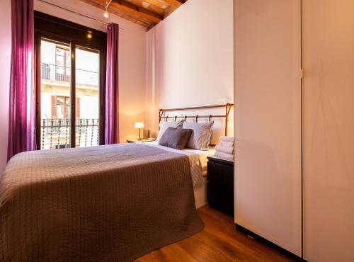 een slaapkamer met een bed en een raam bij Tapioles · Lovely apartment Tapioles in Barcelona