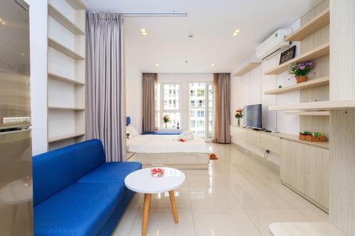 sala de estar con sofá azul y cama en Sky homes Block A, en Ho Chi Minh