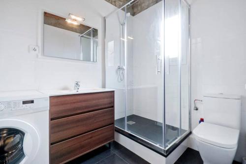 a bathroom with a shower and a toilet and a washing machine at Apartment Poble Nou in Barcelona