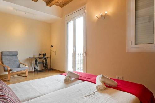 a bedroom with a bed and a chair and a window at Apartment Poble Nou in Barcelona