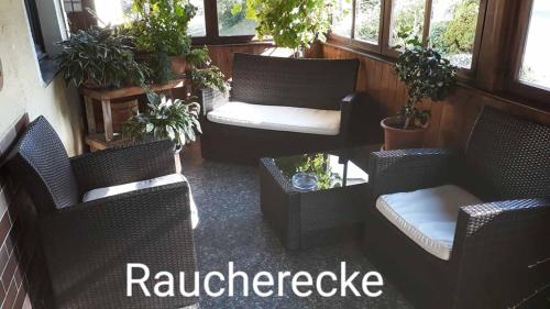 a balcony with wicker chairs and a table with plants at Landgasthof Vogl - Zum Klement in Neukirchen beim Heiligen Blut