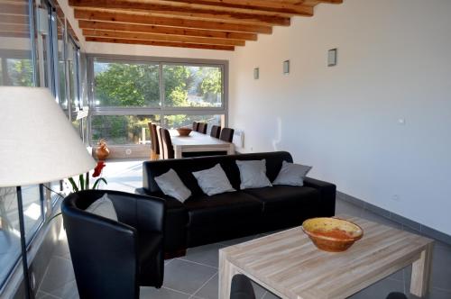 ein Wohnzimmer mit einer schwarzen Couch und einem Tisch in der Unterkunft Chambres d'Hôtes Villa Cardellini in Aullène