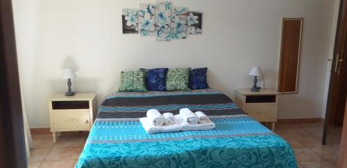 ein Schlafzimmer mit einem Bett mit zwei Handtüchern darauf in der Unterkunft Bed and Breakfast Le petunie in Bari Sardo