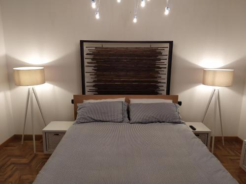 a bedroom with a bed with two lights above it at Casa Chiantishire in Montespertoli