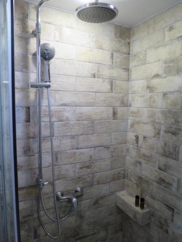 y baño con ducha y pared de piedra. en Porto Gerakas Villas, en Vasilikos