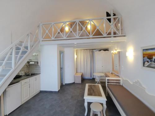 a kitchen with a staircase and a table and chairs at Erato Apartments in Firostefani