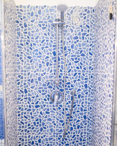 a shower with a blue and white patterned shower curtain at Parco Augusto in Capri