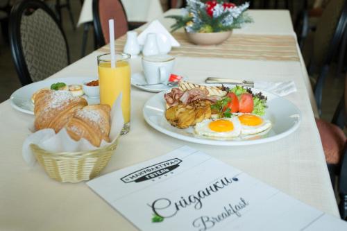 a table with two plates of breakfast foods and drinks at Manufactura Design-Hotel in Khodosovka