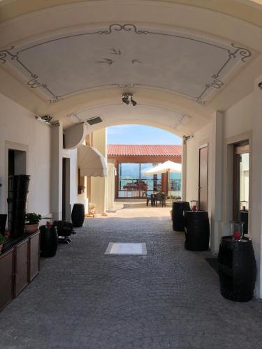 un hall vide avec une arche, une table et des chaises dans l'établissement Hotel Belvedere, à Alice Bel Colle