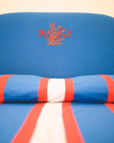 a blue and red surfboard with a red coral on it at Parco Augusto in Capri